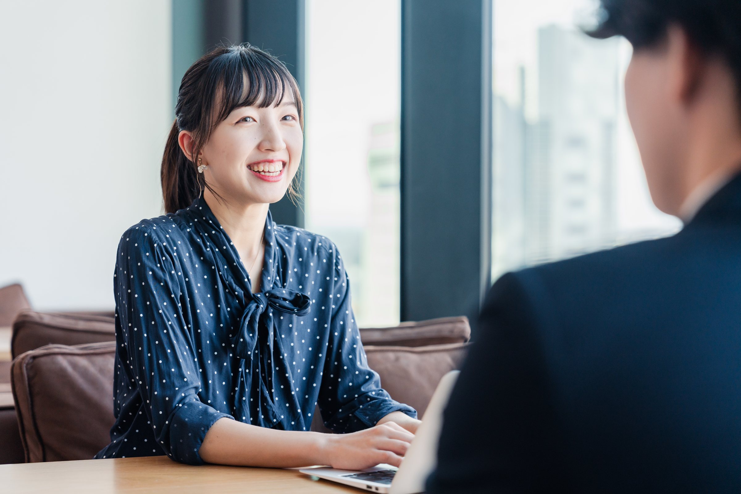 上司と1on1で向き合い、笑顔で話す若手社員